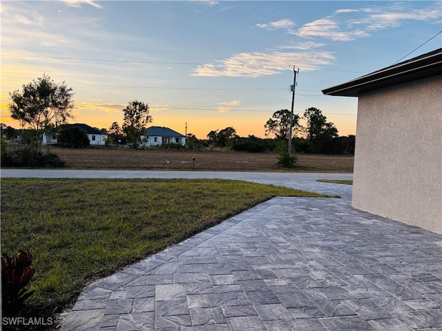 yard at dusk with a patio area