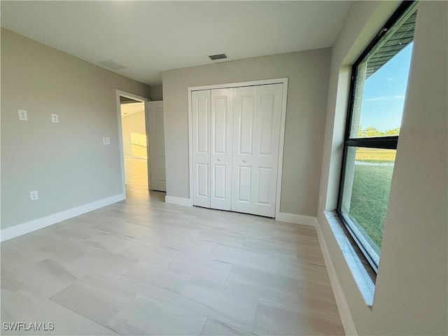 unfurnished bedroom with a closet and multiple windows