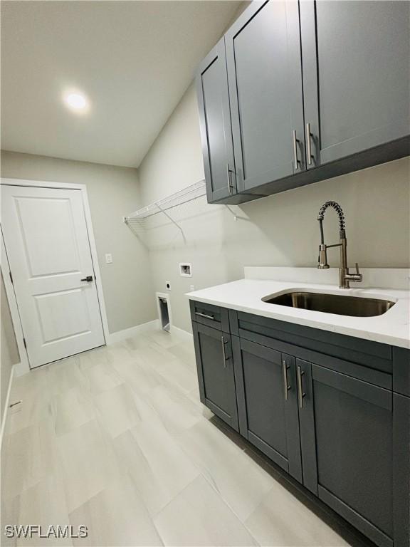 laundry area featuring sink, hookup for a washing machine, cabinets, and hookup for an electric dryer