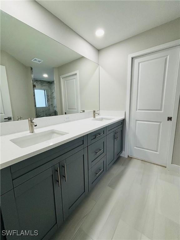 bathroom featuring walk in shower and vanity