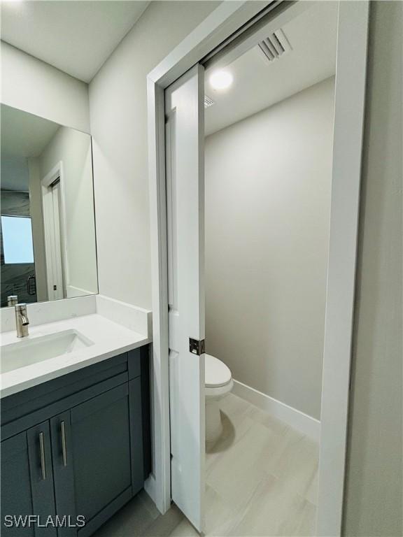 bathroom featuring toilet and vanity