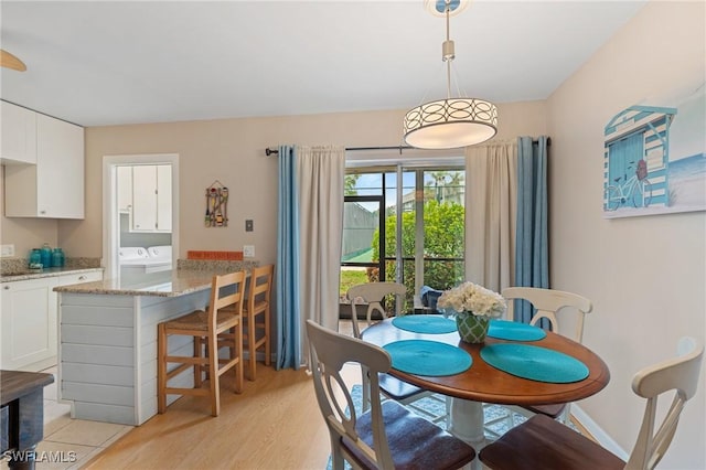 dining room featuring washer and dryer and light wood-type flooring