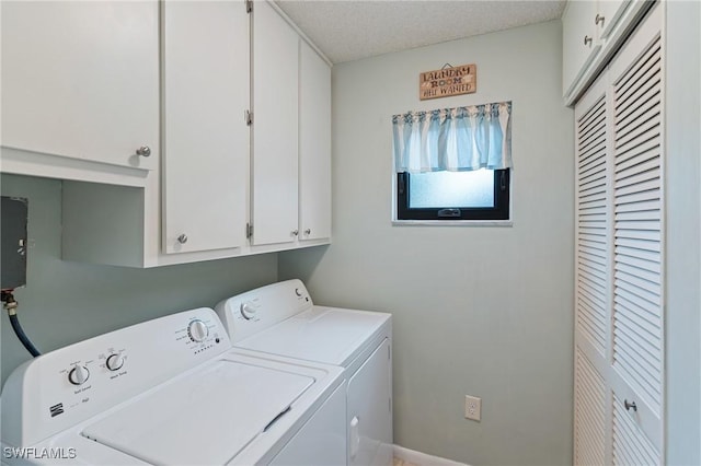 clothes washing area featuring separate washer and dryer, a textured ceiling, and cabinets