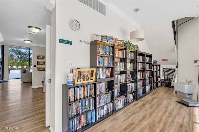 interior space with hardwood / wood-style flooring, a wall of windows, and ornamental molding