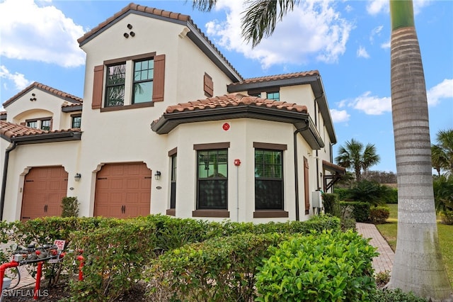 mediterranean / spanish-style home with a garage