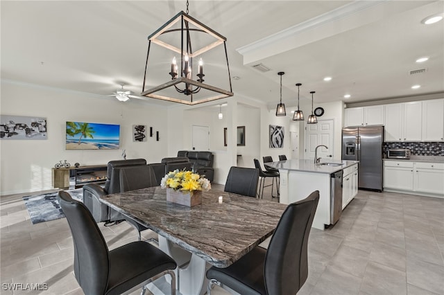 dining area featuring ceiling fan, ornamental molding, and sink