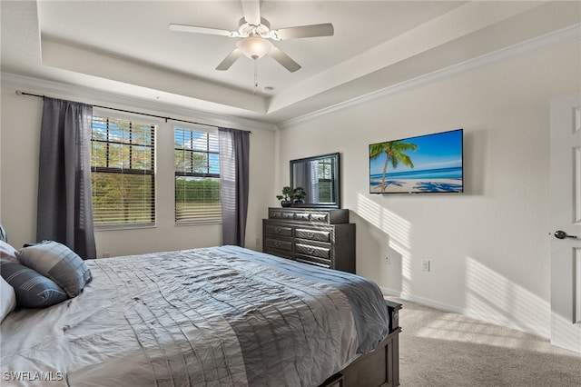 carpeted bedroom featuring ceiling fan, crown molding, and a tray ceiling