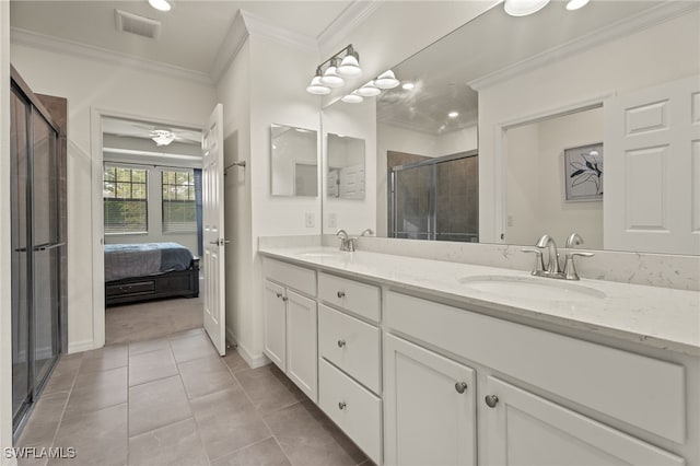 bathroom featuring tile patterned flooring, crown molding, a shower with shower door, and vanity