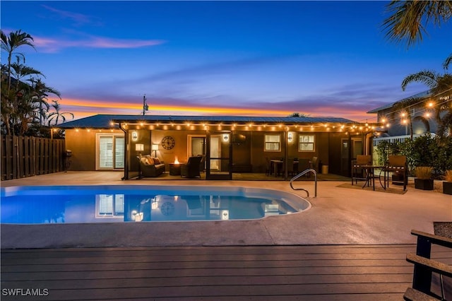 pool at dusk featuring a patio area