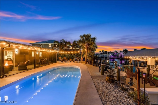 pool at dusk featuring a patio area