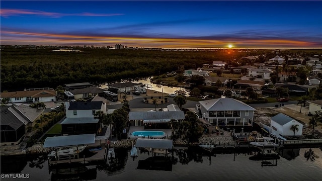 aerial view at dusk featuring a water view