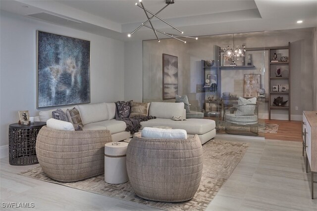 living room with light hardwood / wood-style floors and a raised ceiling