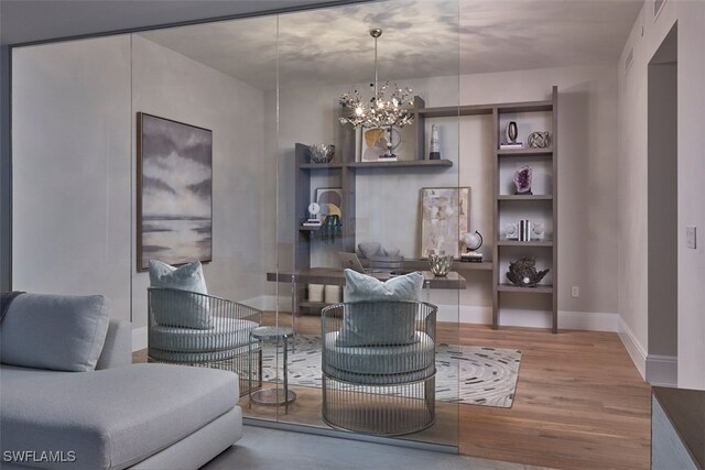 living area with hardwood / wood-style floors and an inviting chandelier