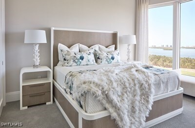 carpeted bedroom with a water view