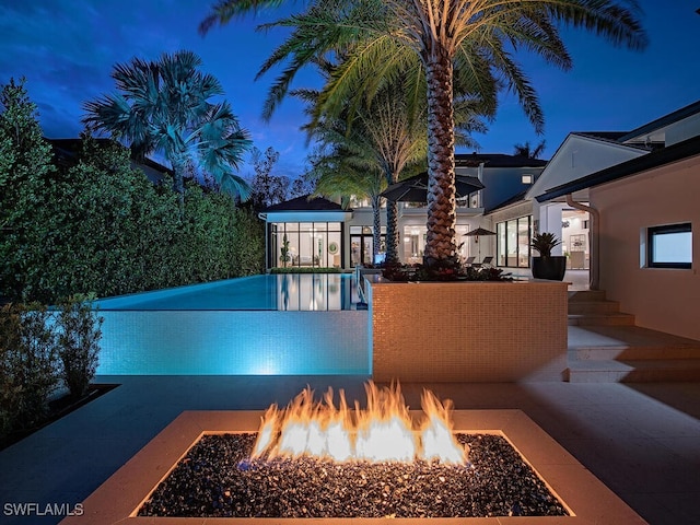 view of pool with a fire pit and a patio