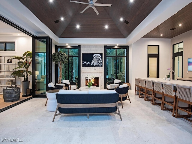 interior space featuring ceiling fan, an outdoor living space with a fireplace, and exterior bar