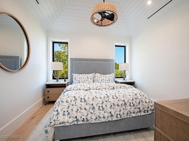 bedroom with wooden ceiling and light hardwood / wood-style flooring