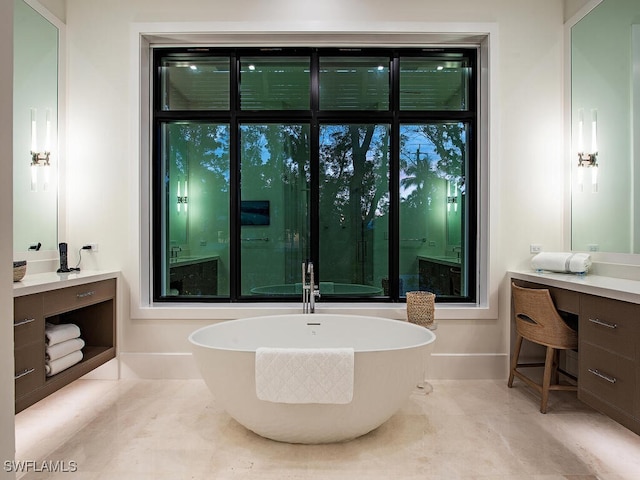 bathroom with tile patterned floors, a tub to relax in, and vanity