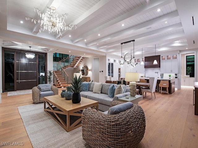 living room featuring beamed ceiling, a chandelier, and light hardwood / wood-style floors