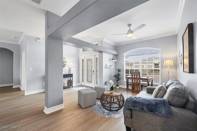 living room featuring crown molding, light hardwood / wood-style floors, and ceiling fan