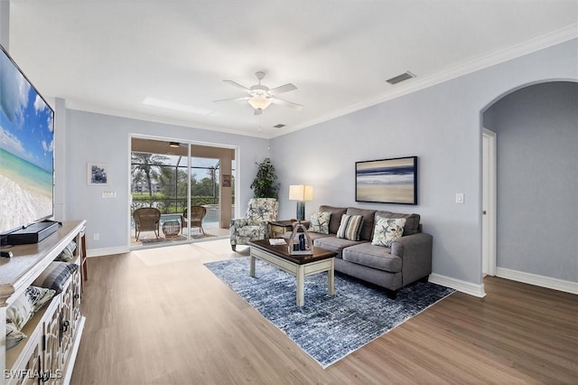 living room featuring hardwood / wood-style flooring, ceiling fan, and crown molding