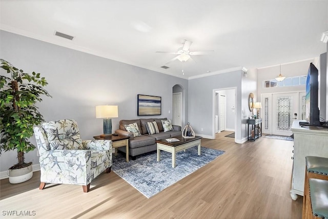 living room featuring hardwood / wood-style flooring, ceiling fan, and crown molding