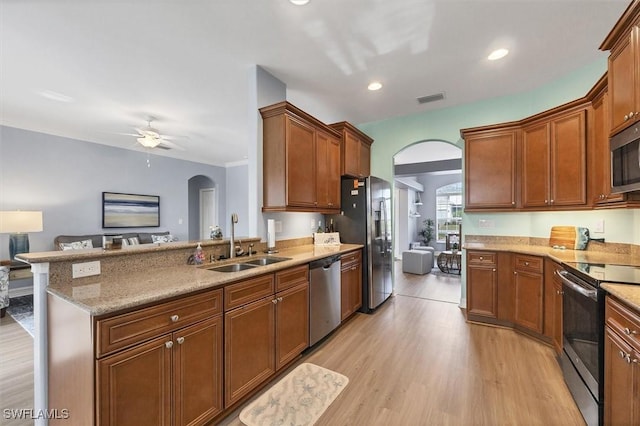 kitchen with sink, light hardwood / wood-style flooring, a breakfast bar, appliances with stainless steel finishes, and kitchen peninsula