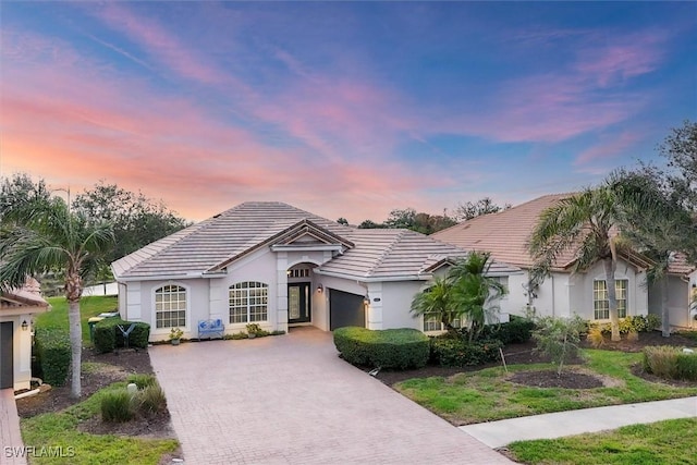 single story home with a garage and a lawn