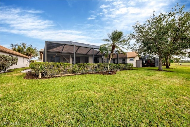 rear view of house with a yard and a lanai