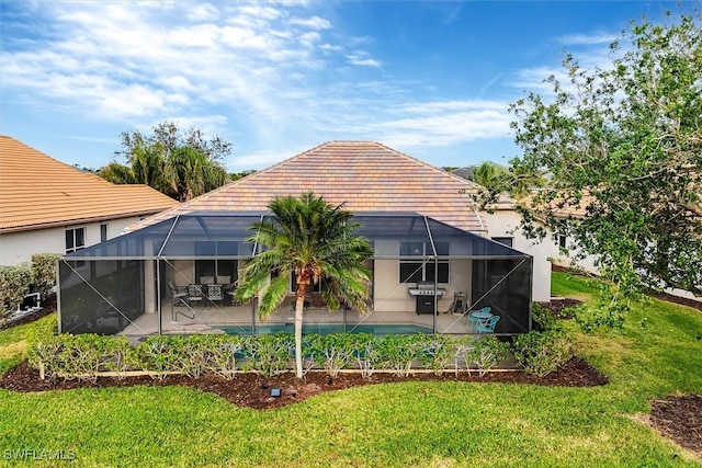 rear view of house featuring a lanai, a lawn, and a patio