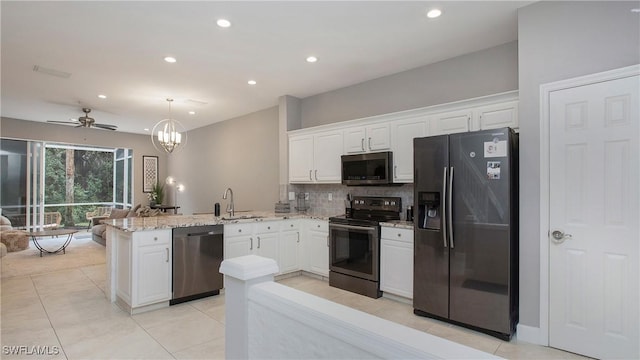 kitchen with sink, white cabinets, kitchen peninsula, ceiling fan with notable chandelier, and appliances with stainless steel finishes