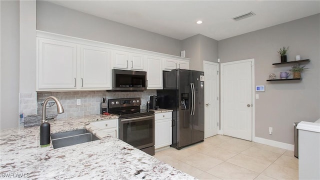 kitchen with appliances with stainless steel finishes, white cabinets, light stone countertops, and sink