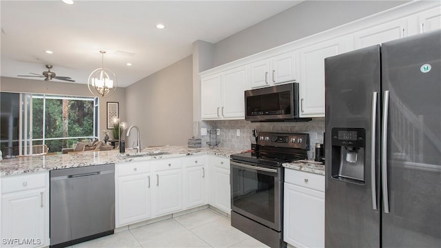 kitchen with sink, white cabinets, ceiling fan with notable chandelier, backsplash, and appliances with stainless steel finishes