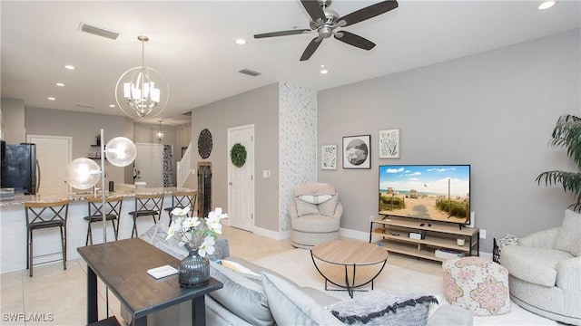 tiled living room featuring ceiling fan with notable chandelier