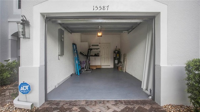 garage featuring electric panel and electric water heater