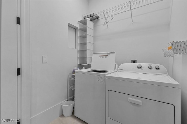 laundry area featuring light tile patterned floors and washing machine and clothes dryer