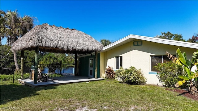 back of property with a yard, a patio, fence, and stucco siding