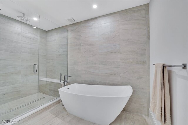 bathroom with plus walk in shower and tile walls