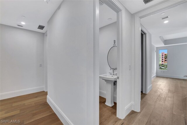 hallway with light hardwood / wood-style floors