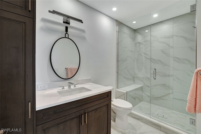 bathroom with vanity, toilet, and a shower with shower door