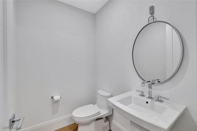 bathroom with sink, hardwood / wood-style flooring, and toilet