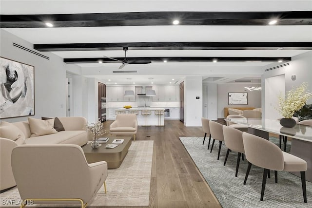 living room with beamed ceiling and light hardwood / wood-style floors