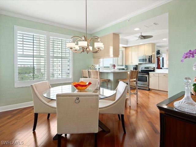 dining area featuring ornamental molding and light hardwood / wood-style flooring