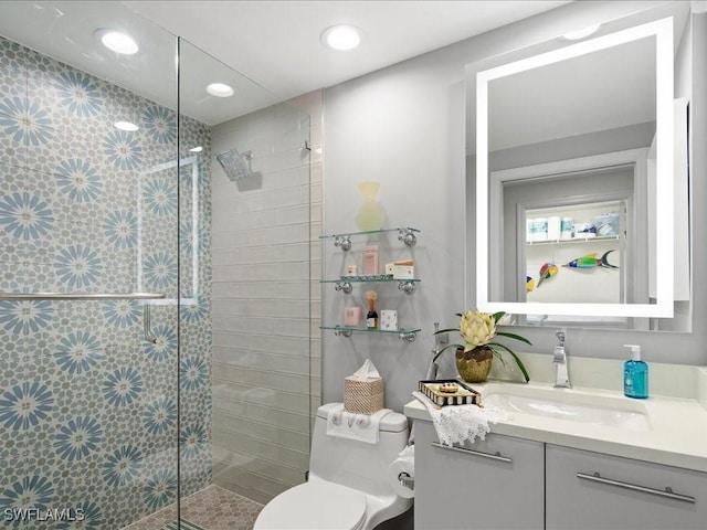 bathroom with toilet, vanity, and tiled shower