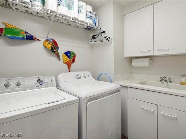 washroom featuring independent washer and dryer, cabinets, and sink