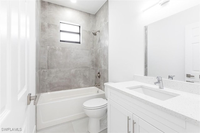 full bathroom featuring vanity, tiled shower / bath combo, and toilet