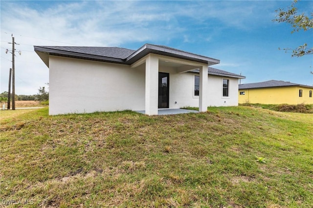 back of property with a yard and a patio area