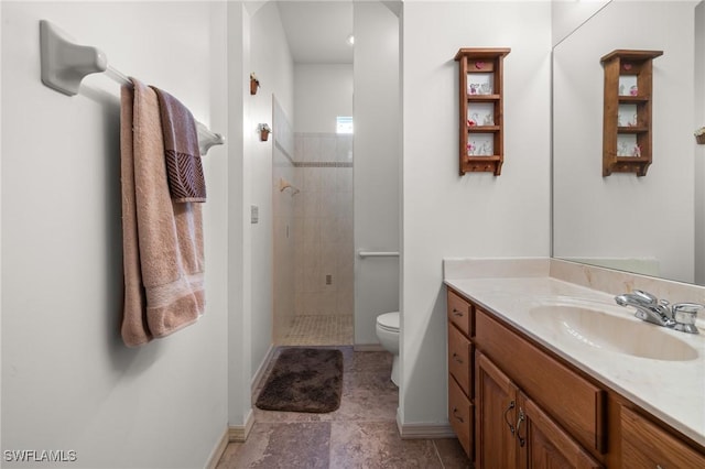 bathroom with toilet, vanity, and a tile shower