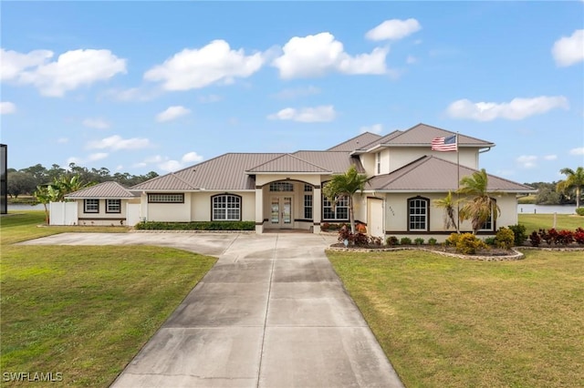 mediterranean / spanish home with french doors and a front yard