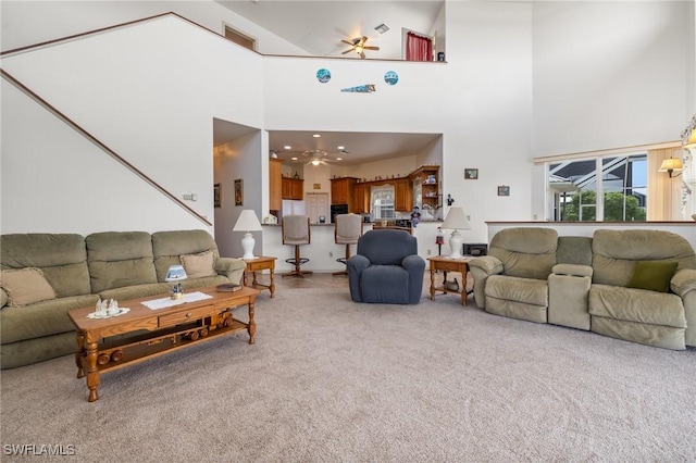 carpeted living room featuring a towering ceiling